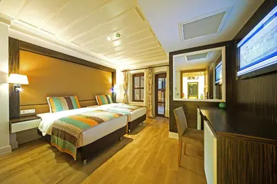a bedroom with a bed and a desk and a television at Ottopera Hotel in Istanbul