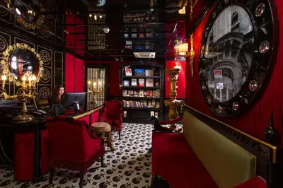a bar with red walls and a clock on the wall at Premist Hotels Sultanahmet in Istanbul
