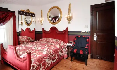 a bedroom with a red bed and a black chair at Premist Hotels Sultanahmet in Istanbul