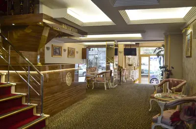 a restaurant with a staircase and a table and chairs at Mekke Hotel Istanbul in Istanbul