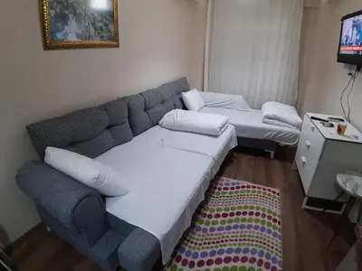 a living room with a couch and two beds at Burak Apart in Istanbul