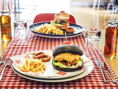two plates of food on a table with a hamburger and french fries at Ibis Istanbul Esenyurt in Istanbul