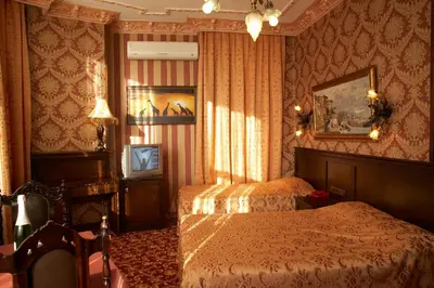 a bedroom with two beds and a table in it at Grand Hotel de Londres in Istanbul