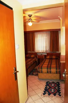 a bedroom with two beds and a ceiling fan at Kadikoy Otel in Istanbul