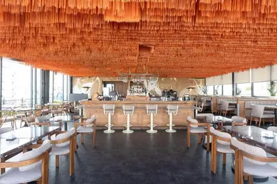 a restaurant with tables and chairs and a bar at Wyndham Grand Istanbul Kalamış Marina Hotel in Istanbul