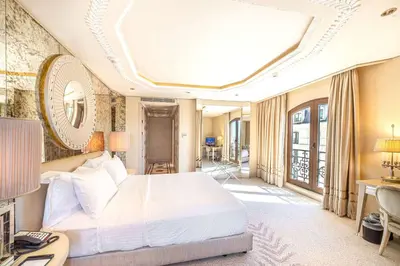 a bedroom with a bed and a desk and a room at Wyndham Grand Istanbul Kalamış Marina Hotel in Istanbul