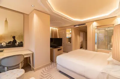 a bedroom with a bed and a desk and a television at Wyndham Grand Istanbul Kalamış Marina Hotel in Istanbul