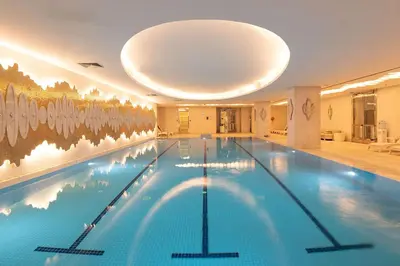 a large swimming pool in a hotel with a ceiling at Wyndham Grand Istanbul Kalamış Marina Hotel in Istanbul