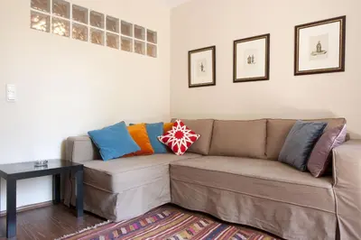 a living room with a brown couch with colorful pillows at Aslan Apartments in Istanbul