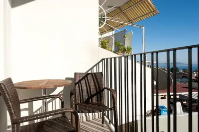 a balcony with two chairs and a table with a view of the ocean at Aslan Apartments in Istanbul