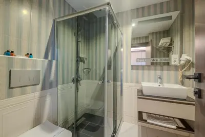 a bathroom with a shower and a toilet and a sink at BEST GARDEN HOTEL in Istanbul