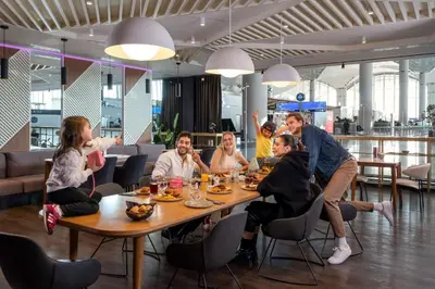 a group of people sitting around a table in a restaurant at YOTEL Istanbul Airport, City Entrance in Istanbul