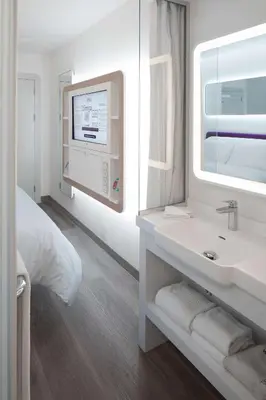 a white bathroom with a sink and a mirror at YOTEL Istanbul Airport, City Entrance in Istanbul