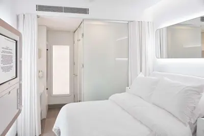a white bedroom with a white bed and a window at YOTEL Istanbul Airport, City Entrance in Istanbul