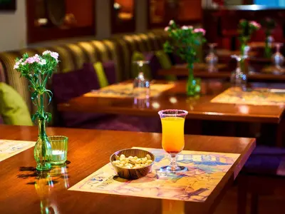 a table with a glass of orange juice and a bowl of peanuts at Feronya Hotel in Istanbul