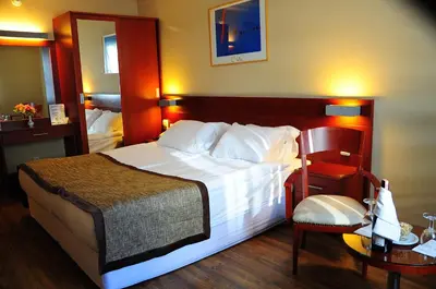 a hotel room with a large bed and a chair at Feronya Hotel in Istanbul