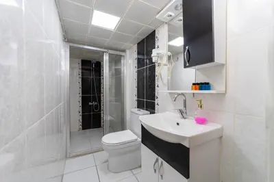 a white bathroom with a toilet and a sink at Taksim Mood in Istanbul