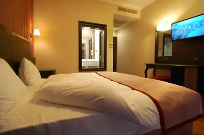 a bedroom with a white bed with a flat screen tv at Sultan Mehmed Hotel in Istanbul