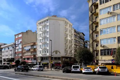 a tall white building on a city street with cars at HOTELOZBEK in Istanbul