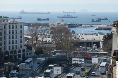 a busy city street with cars and ships in the water at HOTELOZBEK in Istanbul