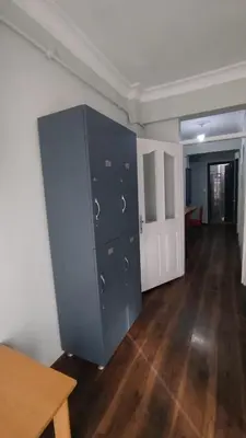 a large blue cabinet in a room with a wooden floor at ivy hostel cafe in Istanbul
