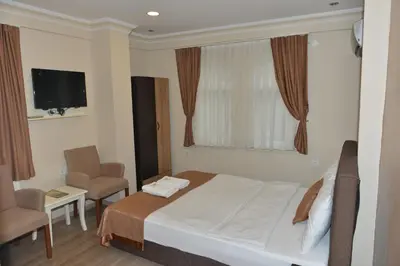 a hotel room with a bed and a chair and a television at Teras Hotel Kağıthane in Istanbul