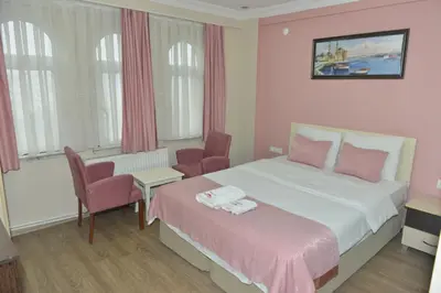 a bedroom with a bed and two chairs and a table at Teras Hotel Kağıthane in Istanbul