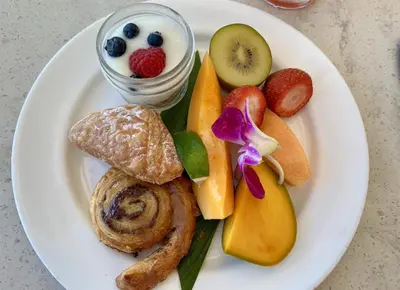 a white plate of food with fruit and bread at Teras Hotel Kağıthane in Istanbul