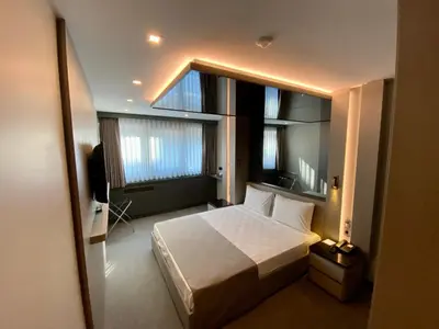 a bedroom with a bed and a large window at Triada Hotel Karaköy in Istanbul