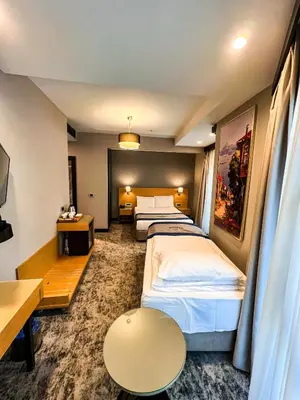 a hotel room with two beds and a table at Triada Hotel Karaköy in Istanbul