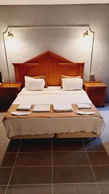 a bedroom with a large bed with a wooden headboard at Elite Hotel City Center Corlu Bed and Breakfast in Corlu