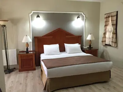a bedroom with a large bed with two night stands and two lamps at Elite Hotel City Center Corlu Bed and Breakfast in Corlu