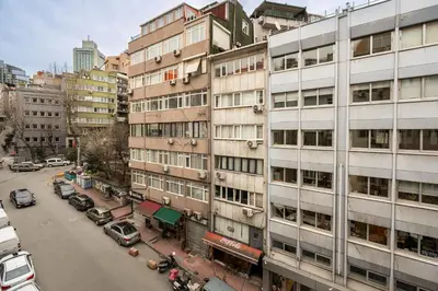 a city street with cars parked in front of a building at Cihangir Palace Hotel in Istanbul