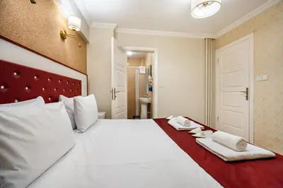 a bedroom with a large white bed with towels on it at Cihangir Palace Hotel in Istanbul