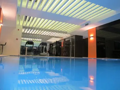a large swimming pool with blue water in a building at Victory Hotel & Spa Istanbul in Istanbul