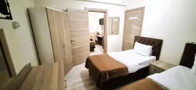 a hotel room with two beds and a mirror at WİND HOTEL in Sakarya