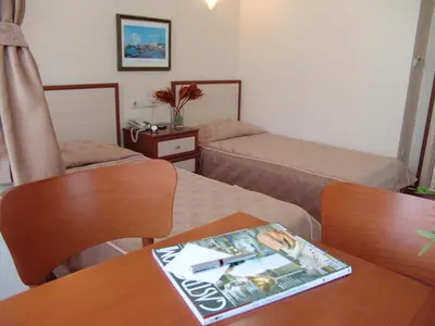 a hotel room with two beds and a magazine on a table at Hotel Nova in Istanbul