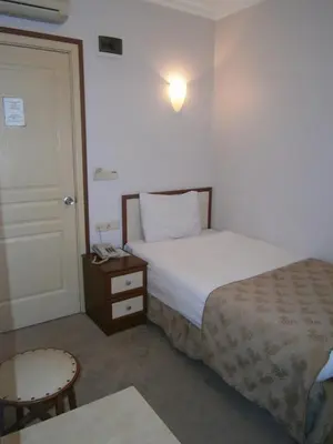 a hotel room with a bed and a table and a door at Hotel Nova in Istanbul