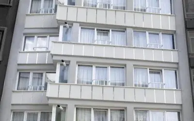 a tall white building with many windows at ELMİR SUİTES Hotel in Istanbul