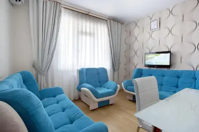 a living room with a blue couch and two chairs at ELMİR SUİTES Hotel in Istanbul