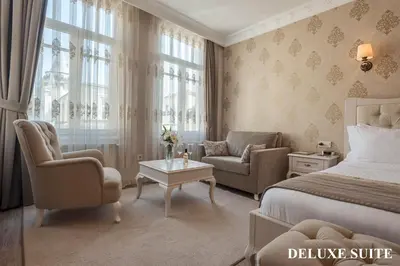 a bedroom with a bed and two chairs and a table at Louis Appartements Galata in Istanbul