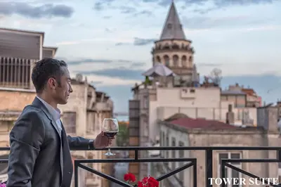 a man in a suit holding a glass of wine at Louis Appartements Galata in Istanbul