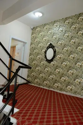 a room with a wall with a floral wallpaper at Şar Apartment Suites in Istanbul