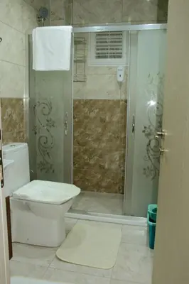 a bathroom with a toilet and a glass shower at Şar Apartment Suites in Istanbul