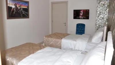 a bedroom with two beds and a picture on the wall at Şar Apartment Suites in Istanbul