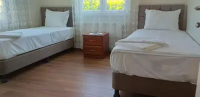 a bedroom with two beds and a night stand with a window at PALACE KIRKPINAR in Sakarya