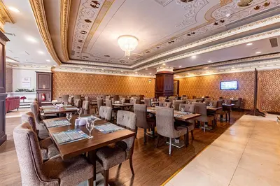 a restaurant with wooden tables and chairs and a ceiling at The Sign Kocaeli Thermal Spa Hotel &Convention Center in Yeniköy