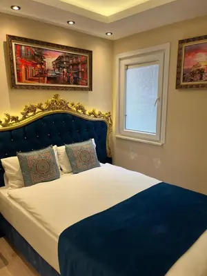 a bedroom with a bed with a blue headboard and a window at Hotel Barbarosa in Istanbul