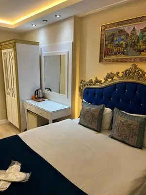 a bedroom with a large bed with a blue headboard at Hotel Barbarosa in Istanbul