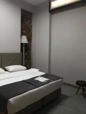 a bedroom with a large bed and a lamp at Jurnal Hotel in Istanbul